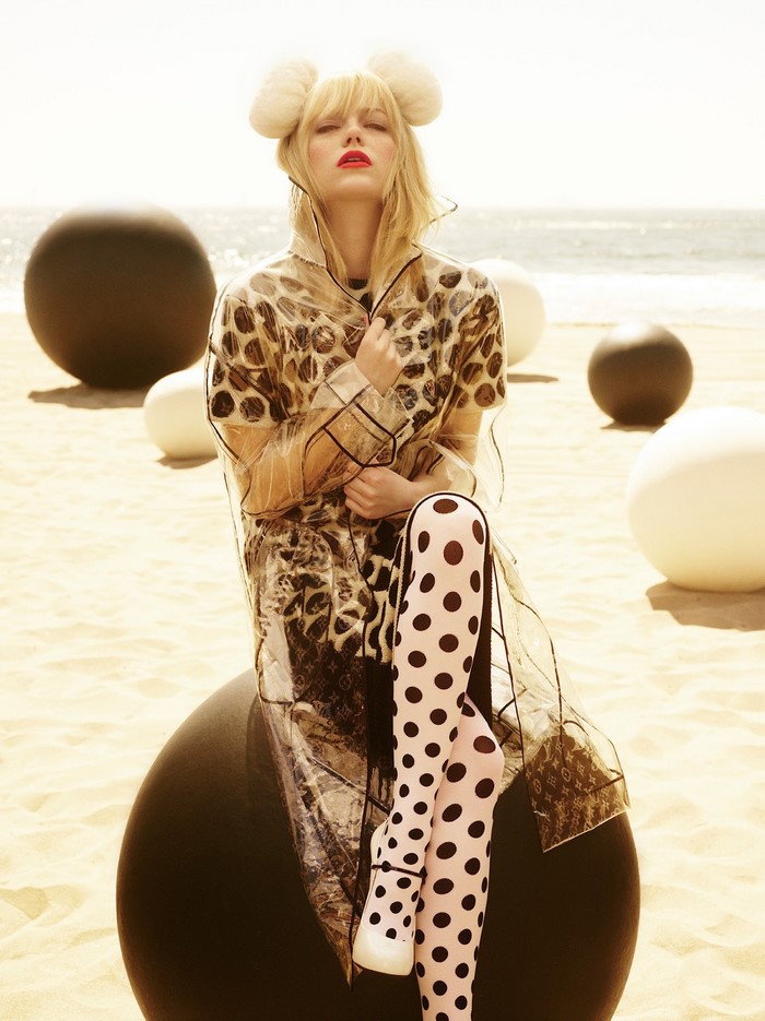 Emma Stone on a beach with large spheres