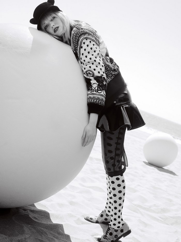 Emma Stone on a beach with large spheres