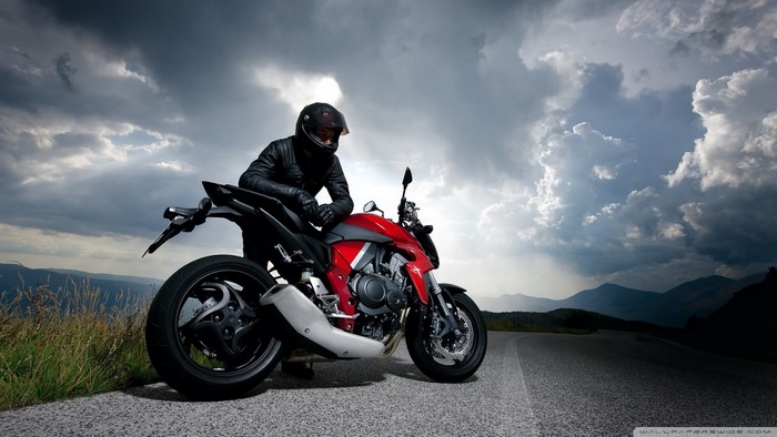 Man in leather jacket on a red Honda motorcycle