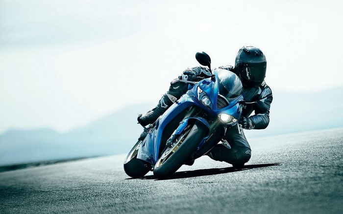 Blue Suzuki motorcycle with rider on road