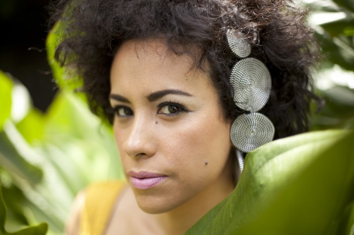 La Yegros portrait with large earrings and green leaves