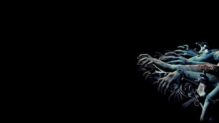 Zombie hands reaching from darkness