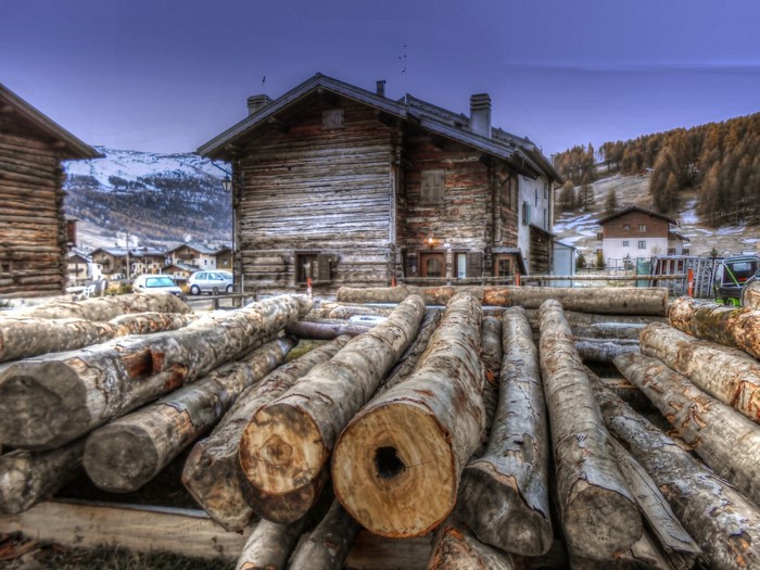 Logs in a rural village with wooden houses and mountains