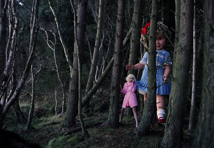Giant doll and small doll in a dark forest
