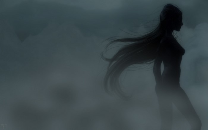 Silhouette of a woman with long hair in fog