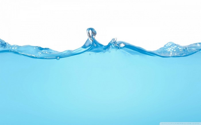 Blue water surface with a wave and bubbles