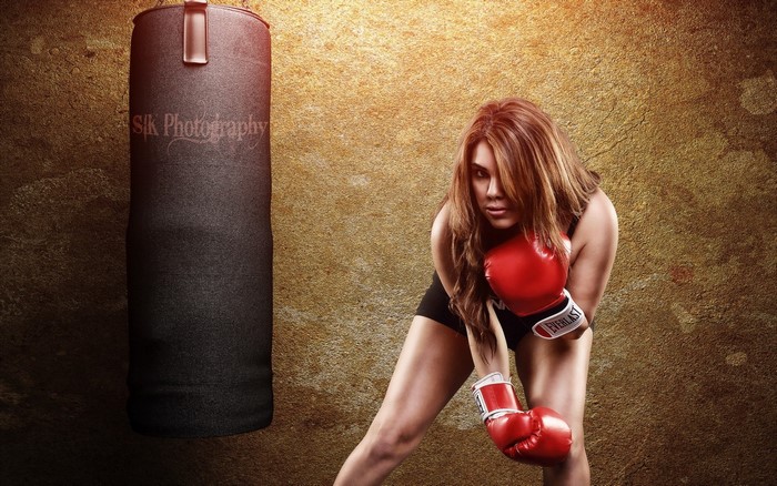 Woman in boxing gloves with punching bag