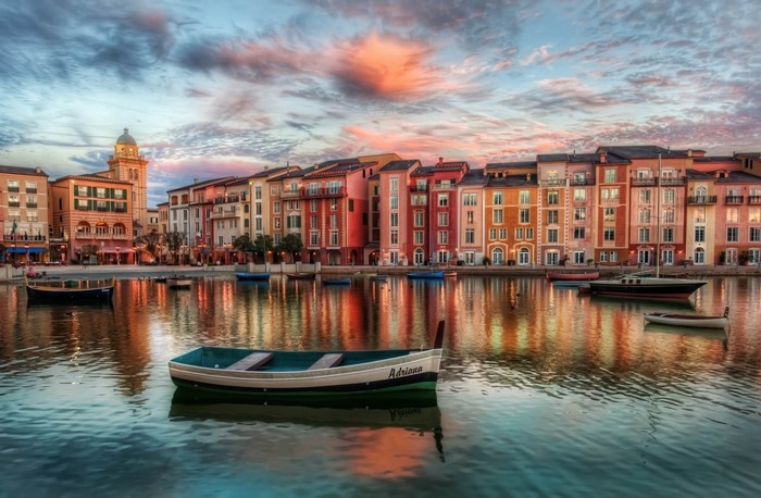 Boats on a canal with colorful buildings at sunset