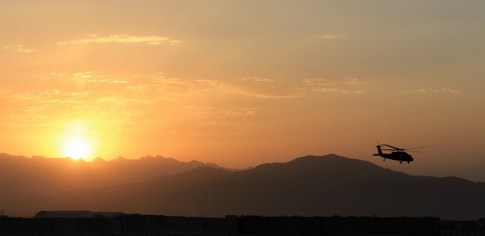 Helicopter flying over mountains at sunset