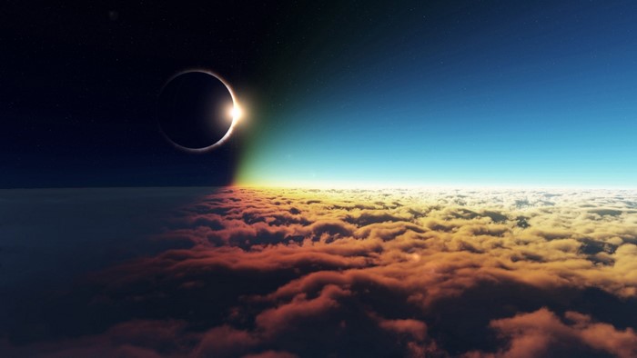 Solar eclipse over clouds at the edge of day and night