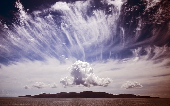 Dramatic clouds over a distant island and the sea