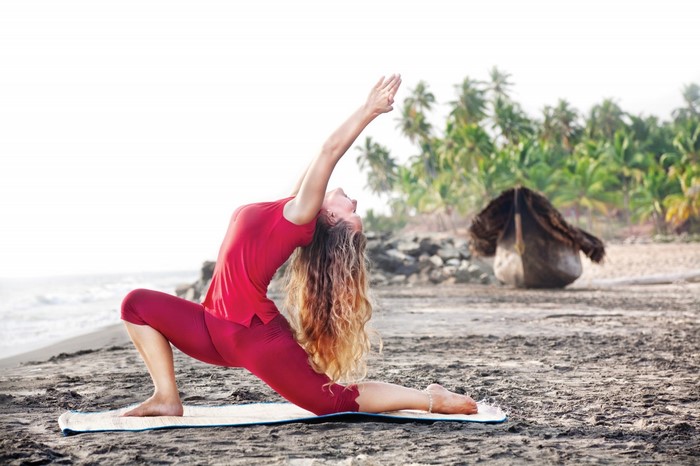 Woman performing yoga on a beach