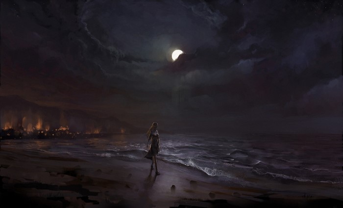 Woman on a beach at night with a city in the background