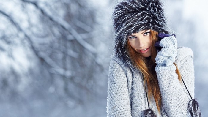 Woman in winter hat and sweater in snow
