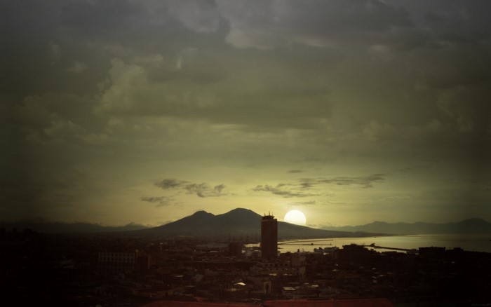 Sunset over a cityscape with mountains and sea