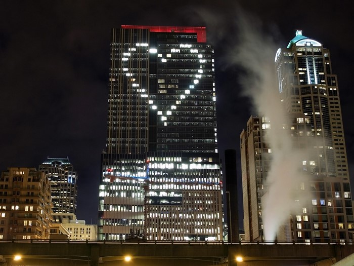 Cityscape at night with heart-shaped lights on skyscraper