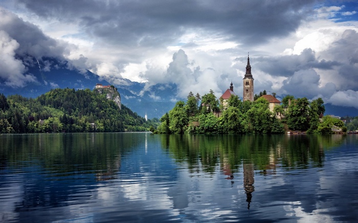 Island church and Bled Castle reflected in a lake