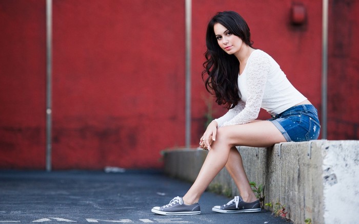 Woman in white top and denim shorts sitting