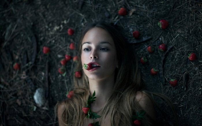 Woman lying on the ground with strawberries