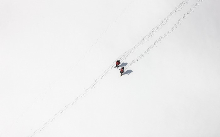 Two skiers in red jackets on a snowy slope