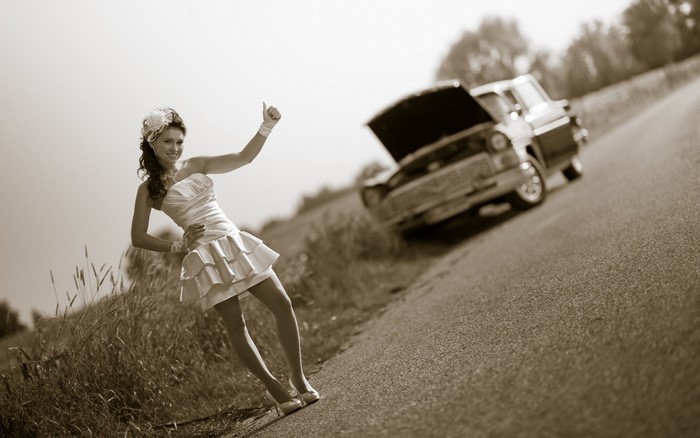 Bride hitchhiking with broken down car