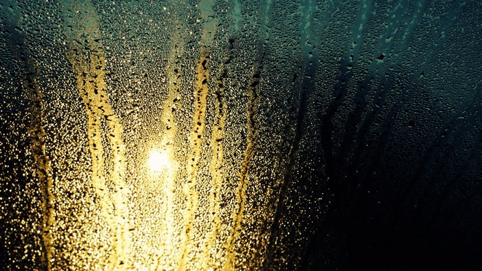 Sunlight through water drops on glass