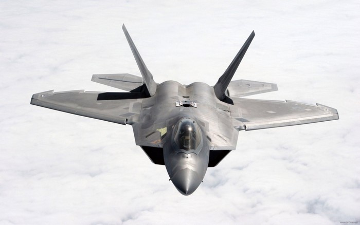 F-22 Raptor fighter jet flying above clouds