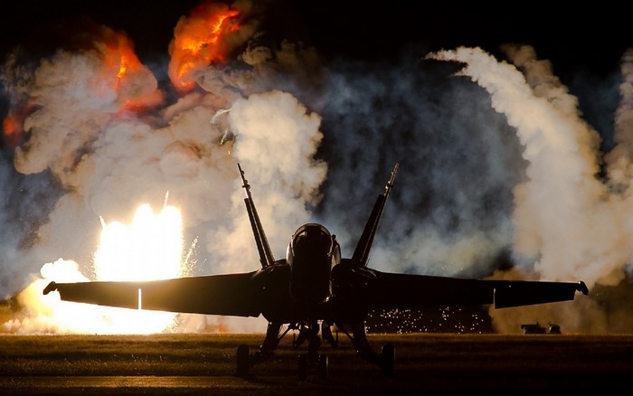 F/A-18 Hornet in front of explosions and smoke