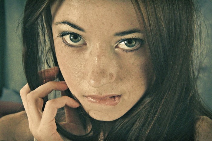 Woman with freckles biting her lip