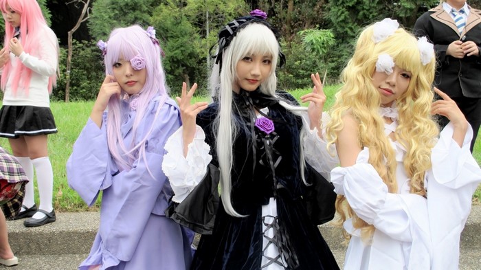 Cosplayers in anime-inspired outfits posing outdoors