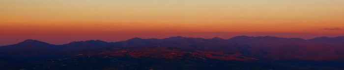 Mountain range at sunset with orange and red sky