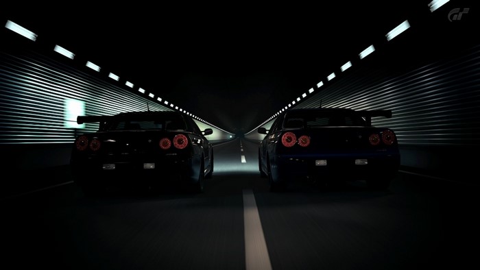Two Nissan Skyline GT-R R34s racing in a tunnel