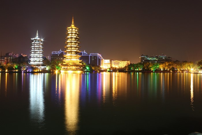 Two pagodas illuminated at night reflected in a lake in Guilin