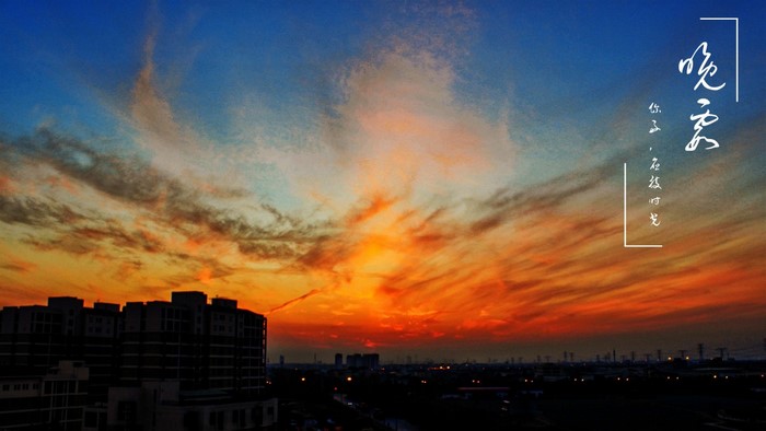 Sunset over a city skyline with dramatic clouds