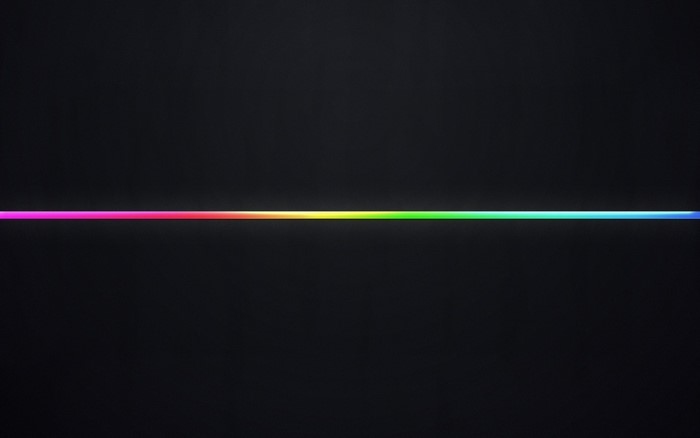 A horizontal line of rainbow light on a dark background