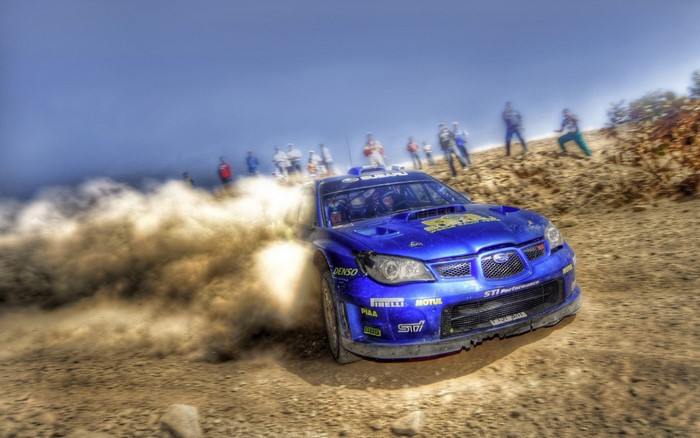 Blue Subaru Impreza WRX STI rally car kicking up dust