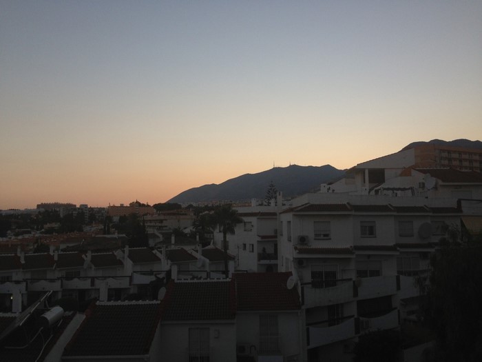 Cityscape at sunset with mountains in the background