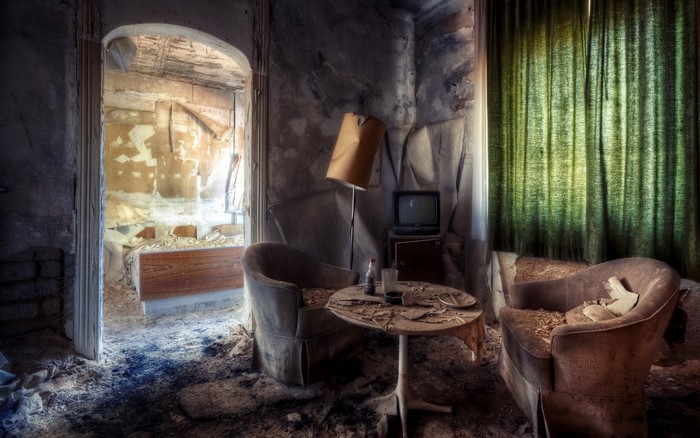 Abandoned room with furniture and TV