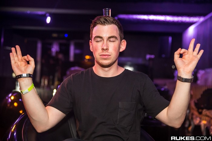 DJ Hardwell meditating with a shot glass on his head