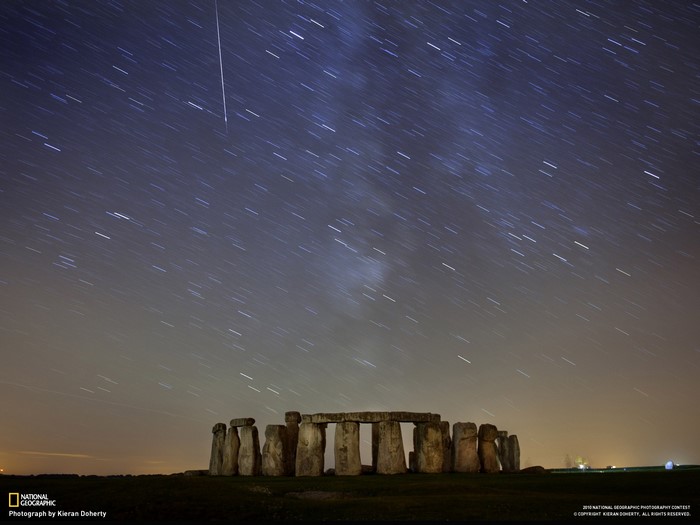 Stonehenge at night with meteor shower