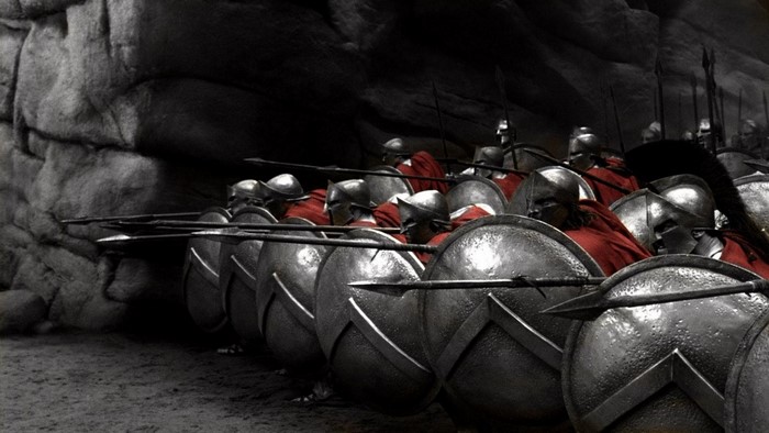 Spartan soldiers with shields and spears in a cave