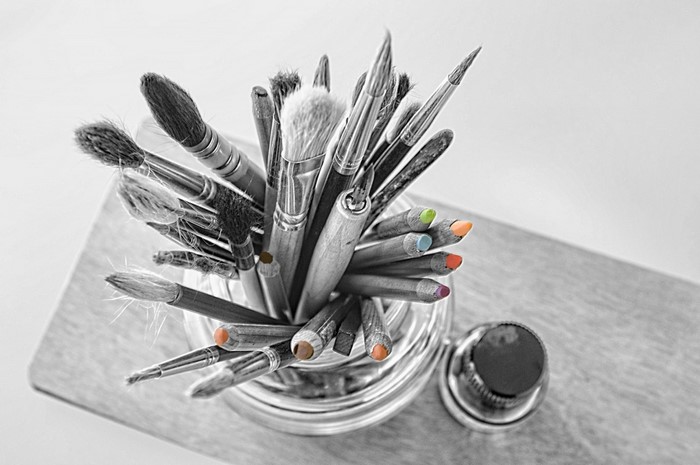 Art brushes and colored pencils in a jar