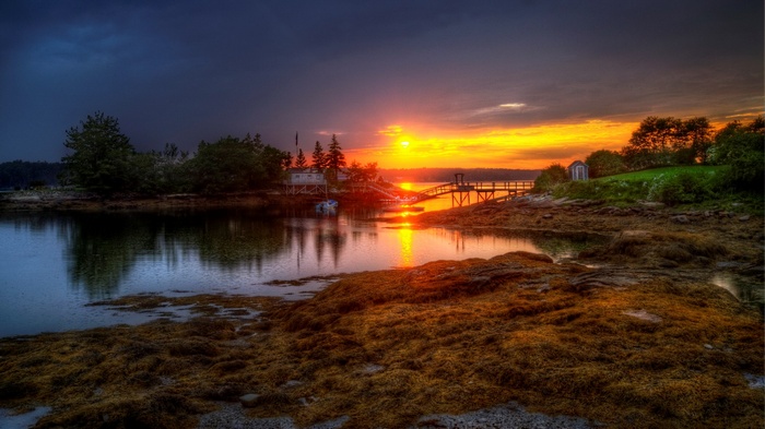 Sunset over a coastal landscape with a dock