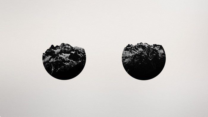 Two circular mountain range illustrations on a plain background