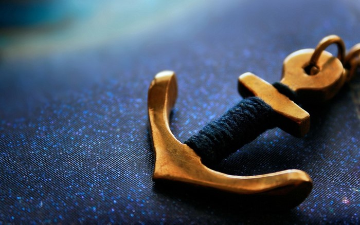 Close-up macro photography of a golden anchor charm