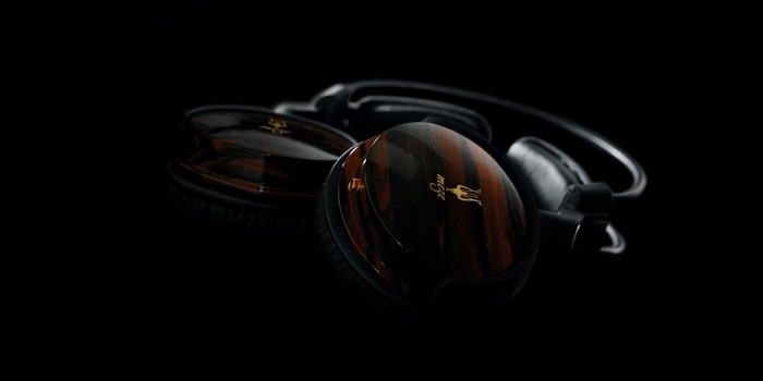 Wooden headphones with gold logo on black background