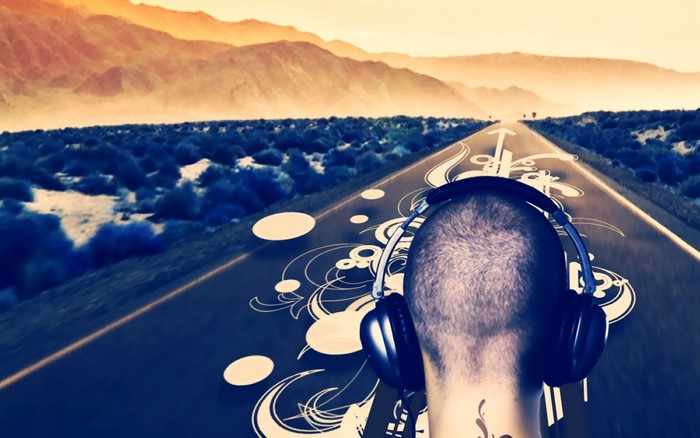 Man with headphones on a road with mountains