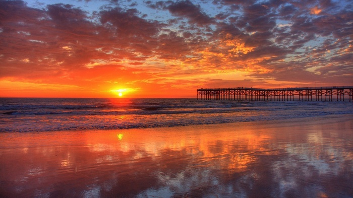 Sunset over the ocean with a pier