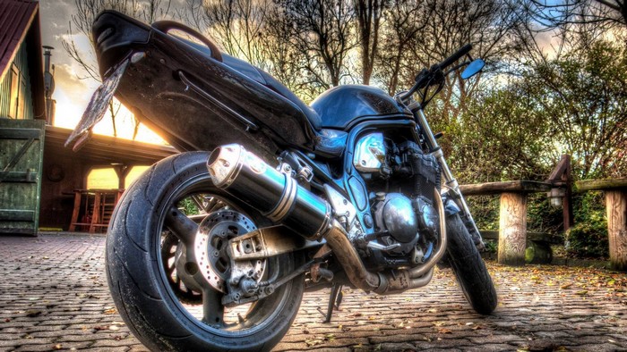 Suzuki motorcycle parked on cobblestone path