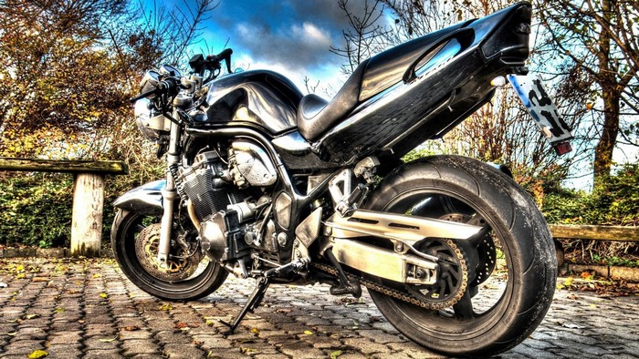 Black Suzuki motorcycle parked on cobblestone